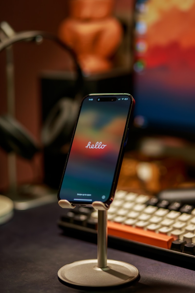 a cell phone on a stand next to a keyboard